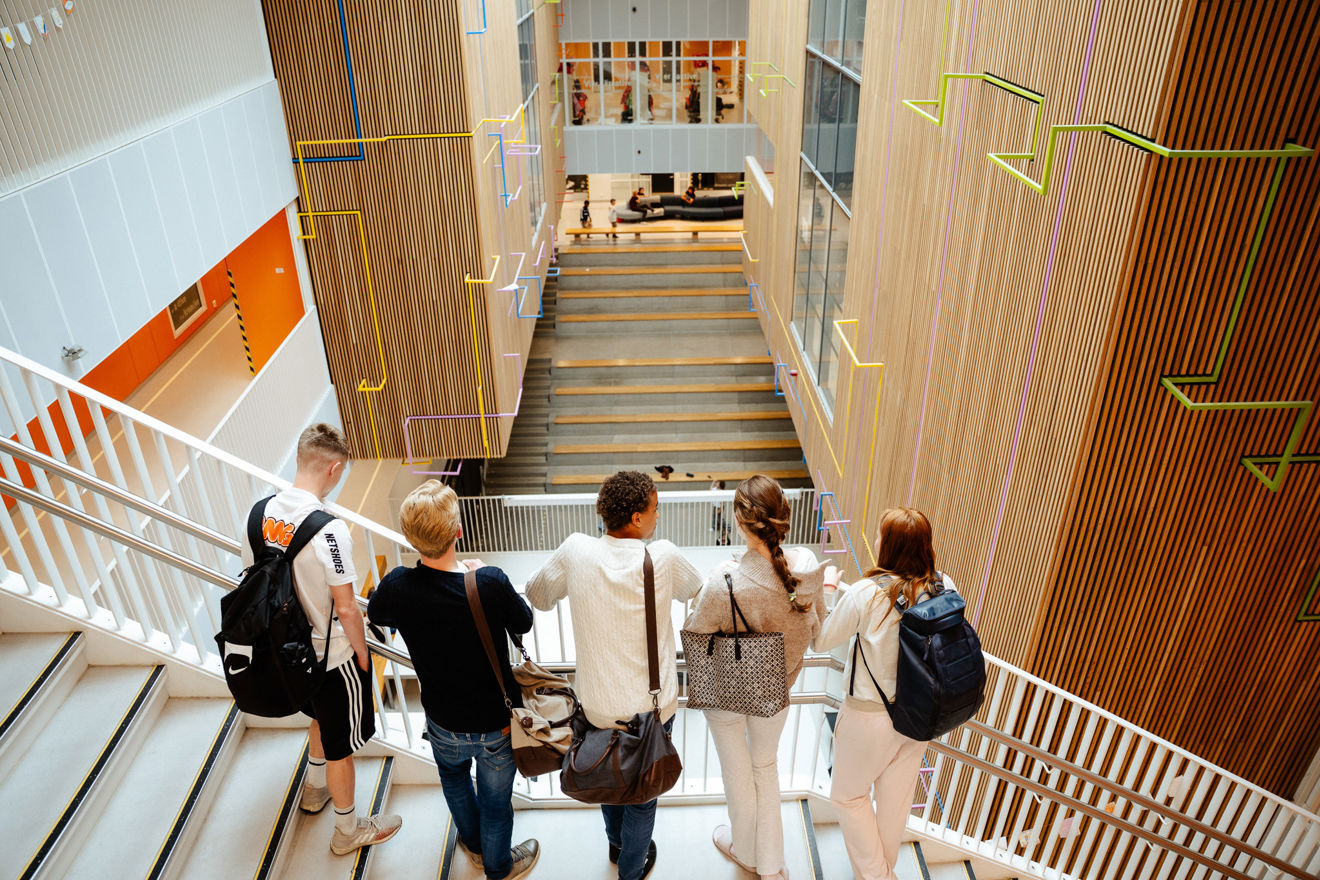 En gruppe elever på et fellesareal på en skole.