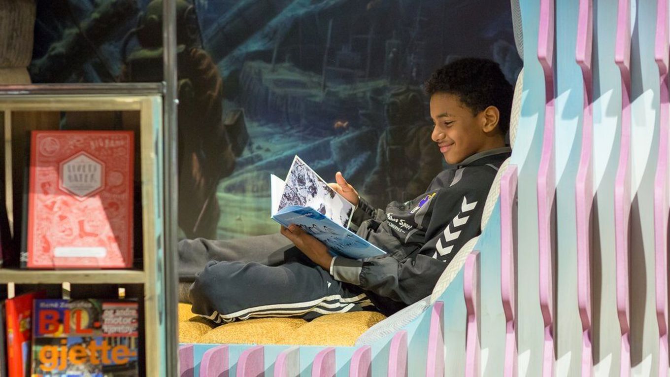 Foto: Deichman / Oslo kommune gutt som leser en bok